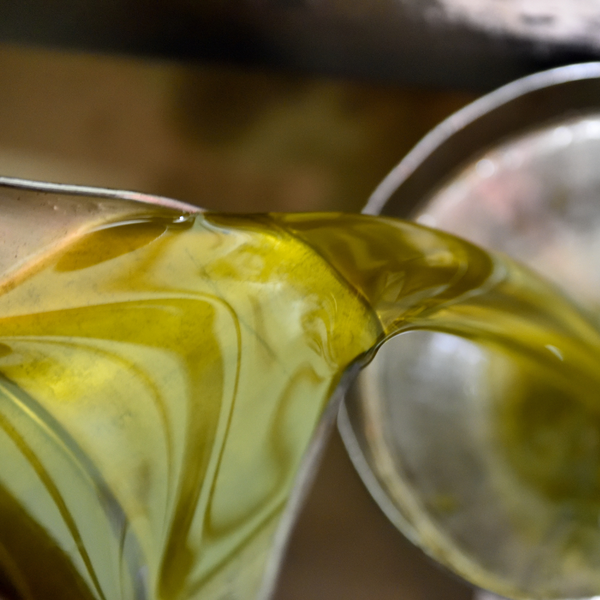 huile olive verte émeraude versée dans un entonnoir